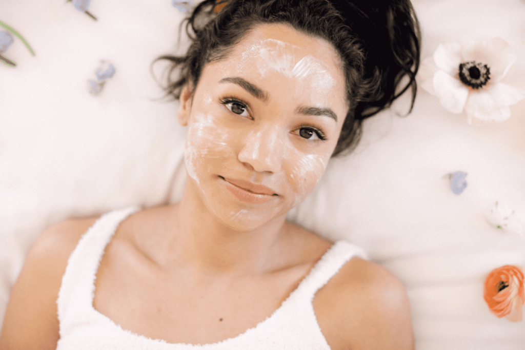 young woman with skincare product on her face